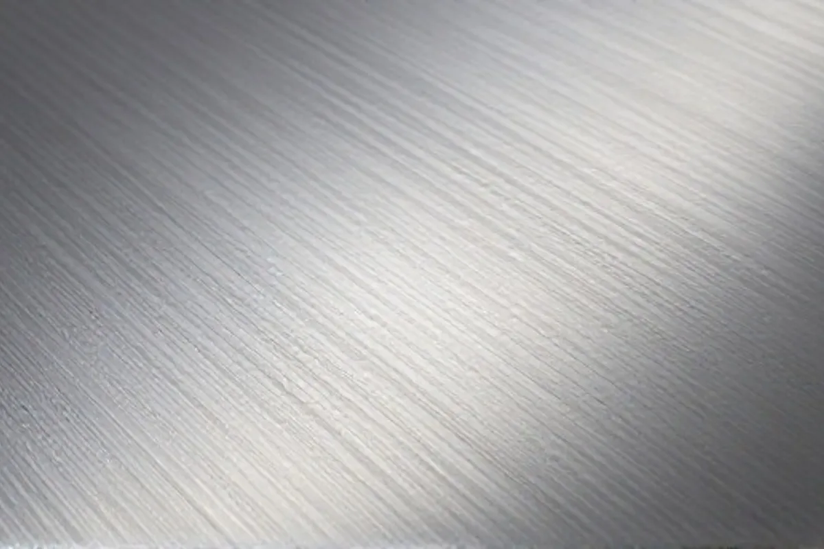 Brushed metal surface finish with directional grain texture patterns